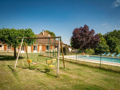 - une balançoire dans une cour à côté d'une piscine dans l'établissement Gite Les Vitarelles, à Besse