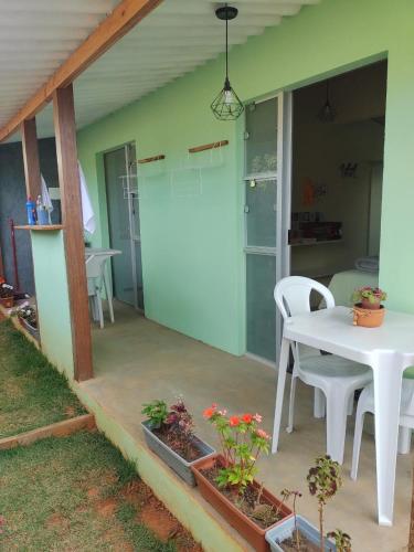 eine Terrasse mit einem weißen Tisch und Stühlen in der Unterkunft Flores do Cerrado in Alto Paraíso de Goiás