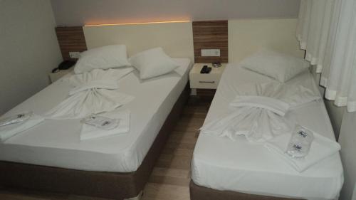 two beds in a hotel room with white sheets at Kadikoy Bade 3 Hotel in Istanbul