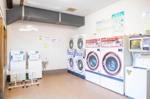 a laundry room with two washing machines and a tv at Hotel Nami in Kumano