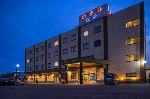 a large building with a sign on top of it at Hotel Nami in Kumano