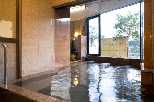 a hallway with a pool of water in a building at Hotel Nami in Kumano
