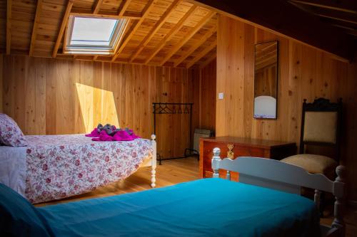 a room with two beds and a table and a window at Domus Nostra in Furnas