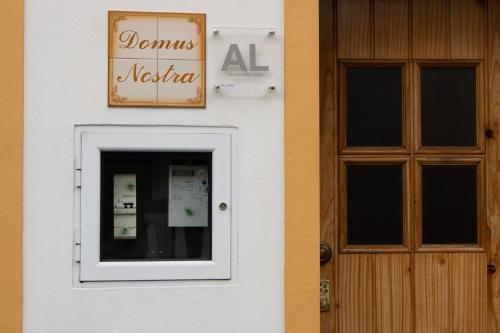 a door and a sign on the side of a building at Domus Nostra in Furnas