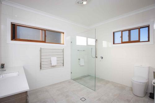 een badkamer met een glazen douche en een toilet bij Sovereign Hill Country Villa in Lovedale
