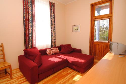 a red couch in a living room with a window at Parko Vila in Druskininkai