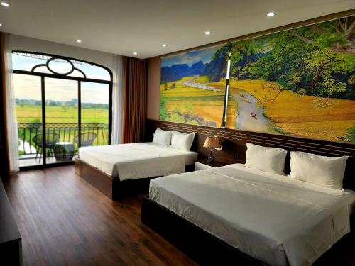 a room with two beds and a large painting on the wall at Lotus Hotel Ninh Bình in Ninh Binh