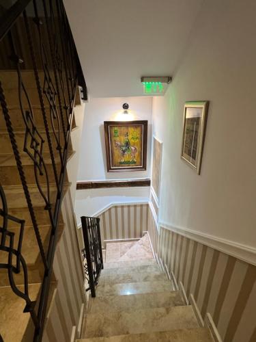 a hallway with stairs and a painting on the wall at Hotel Boutique Cathedral Plaza Residences room for rent downtown in Bucharest