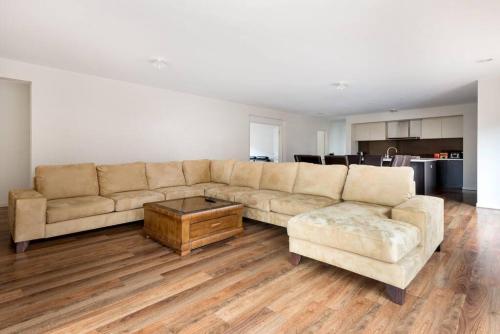 a living room with a couch and a coffee table at Holiday Rental 6 KING BD 12PPL in Truganina