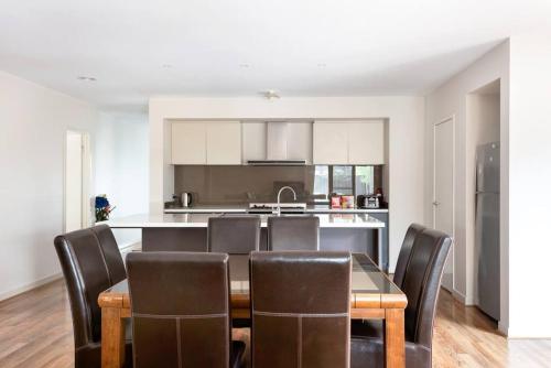 a kitchen and dining room with a table and chairs at Holiday Rental 6 KING BD 12PPL in Truganina