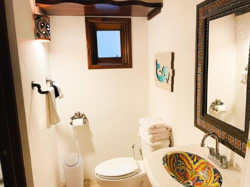 a bathroom with a toilet and a sink and a mirror at Casa Boho 1 in Sayulita