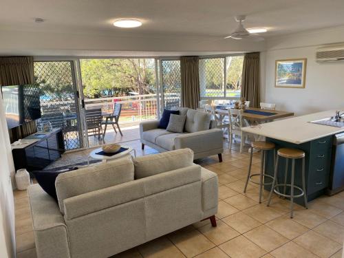 a living room with a couch and a table and a kitchen at Belvedere Apartments in Caloundra