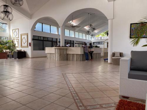 a lobby with people standing at a counter in a building at Flat Sea & Sun Monte Vista in Sosúa