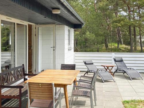 a wooden table and chairs on a patio at 6 person holiday home in Nex in Spidsegård