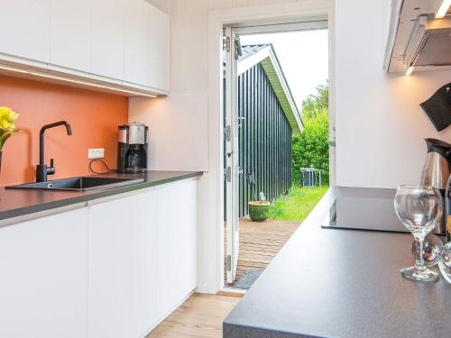 a kitchen with an open door to a yard at 8 person holiday home in Hemmet in Falen