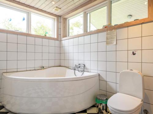 a bathroom with a tub and a toilet at Tranquil Oasis in Rindby in Fanø