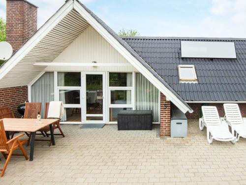 Casa con patio con mesa y sillas en 4 person holiday home in Ringk bing, en Søndervig