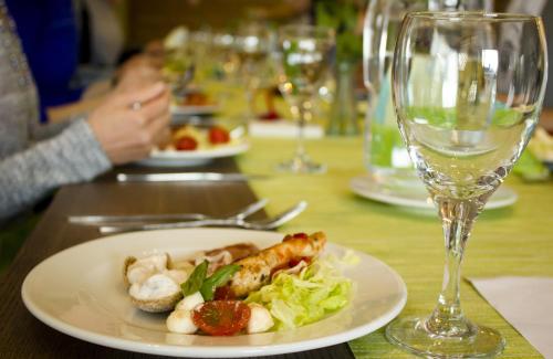 a plate of food on a table with a wine glass at Santasport Resort in Rovaniemi