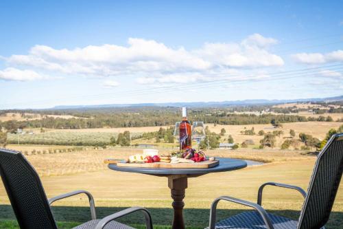 a table with a plate of food and two chairs at Sovereign Hill Country Estate in Lovedale