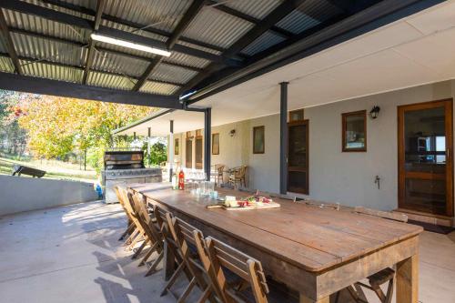 a large wooden table and chairs in a patio at Sovereign Hill Country Estate in Lovedale