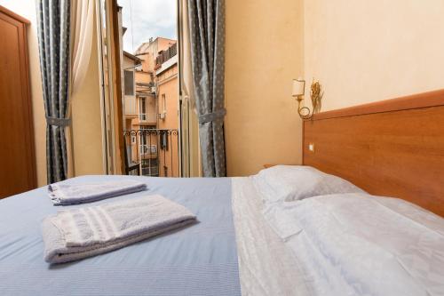 a bedroom with a bed with two towels on it at Allegria Fitzroy Cesr in Rome