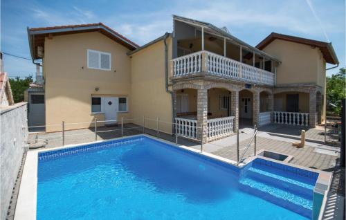 a villa with a swimming pool in front of a house at Gorgeous Apartment In Kakma With Wifi in Kakma