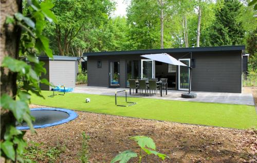 a small black house with a backyard with a playground at Cozy Home In Epe With Wifi in Epe