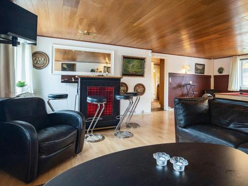 Elle comprend un salon doté d'un mobilier en cuir et d'une cheminée. dans l'établissement 10 person holiday home in Karby, à Karby