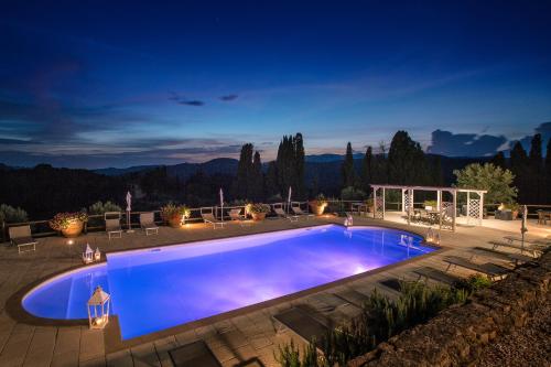 a large swimming pool in a backyard at night at Tenuta Mocajo in Guardistallo