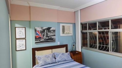 a bedroom with a bed and some pictures on the wall at Vem pra cá! Localização Privilegiada! in Guarapari