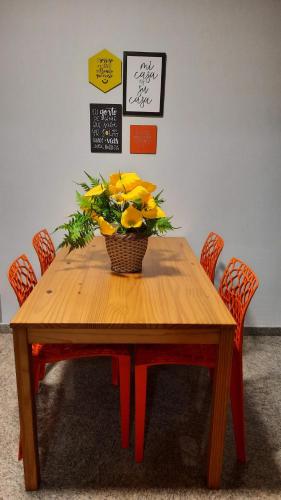 a wooden table with a basket of flowers on it at Vem pra cá! Localização Privilegiada! in Guarapari