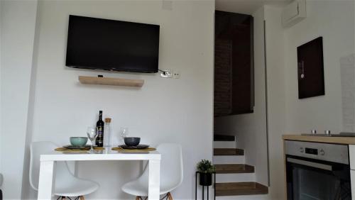 a living room with a white table and a tv on the wall at Apartment Zrinka in Rukavac