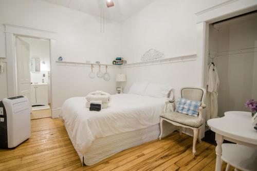 1 dormitorio blanco con 1 cama y 1 silla en Mayson Room BW Boutique Hotel, en Central Lake
