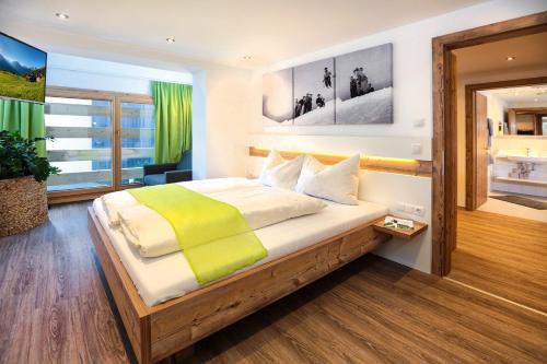 ein Schlafzimmer mit einem großen Bett und einer gelben Decke in der Unterkunft Sunup Appartements Sölden in Sölden