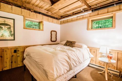 a bedroom with a bed in a room with wooden walls at Northern Nights Chalet by Wanderlust Abodes in Bellaire