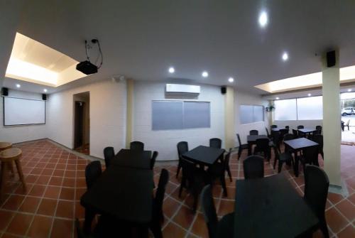a room with tables and chairs and a projection screen at HOTEL ARRECIFE in Santa Veronica