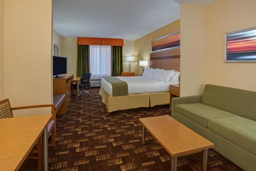 a hotel room with a bed and a couch at Holiday Inn Express Fort Lauderdale Airport South, an IHG Hotel in Dania Beach