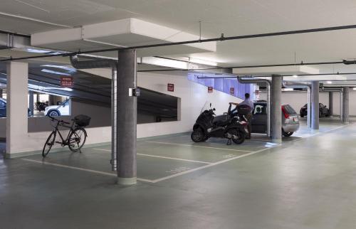 a parking garage with a motorcycle and a bike at Hôtel Les Nations in Geneva