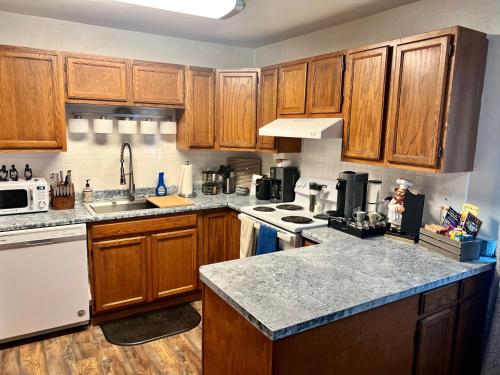 a kitchen with wooden cabinets and marble counter tops at The Perfect 3 Bedroom Apartment - Central location in Fairbanks