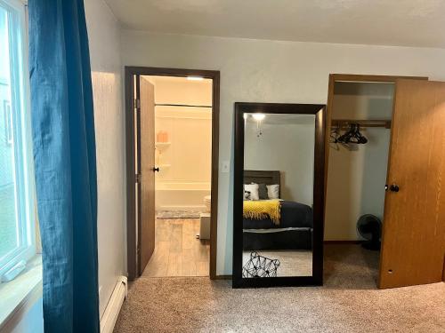 a mirror in a room with a bed and a bathroom at The Perfect 3 Bedroom Apartment - Central location in Fairbanks