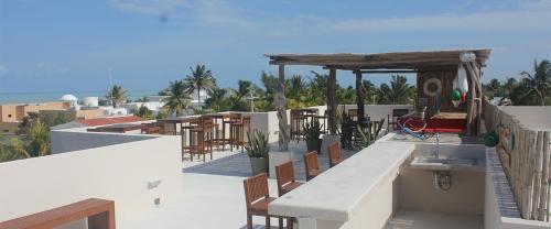 a balcony with tables and chairs on a building at Pedacito de cielo in Progreso