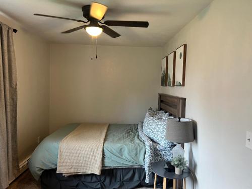 a bedroom with a bed with a ceiling fan at The Perfect 3 Bedroom Apartment - Central location in Fairbanks