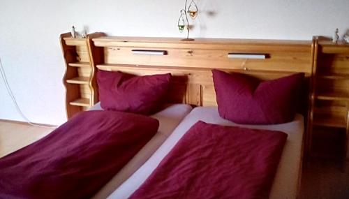 two beds sitting next to each other with purple pillows at Haus Alpenblick in Zenting