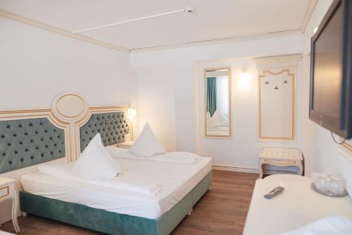 a hotel room with two beds and a tv at Hotel Miruna in Sîmbăta de Sus