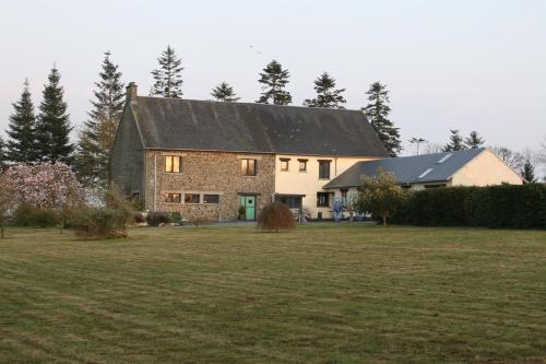 a large house with a grass field in front of it at The Magnolias B&B in Moyon
