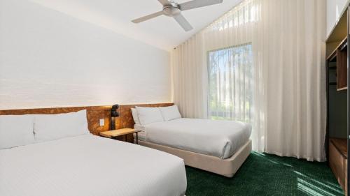 a hotel room with two beds and a window at Eden Oak Geelong in Geelong