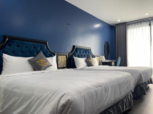1 dormitorio con 2 camas grandes y paredes azules en Khách Sạn Century Tam Đảo en Vĩnh Yên
