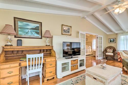 a living room with a television on a wooden entertainment center at Charming Hyannis Cottage 1 Mi to Beach! in Hyannis