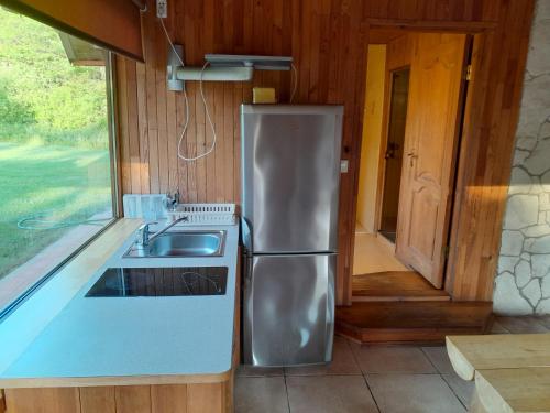 uma cozinha com um frigorífico de aço inoxidável e um lavatório em Guest house Vilciņi em Bernāti