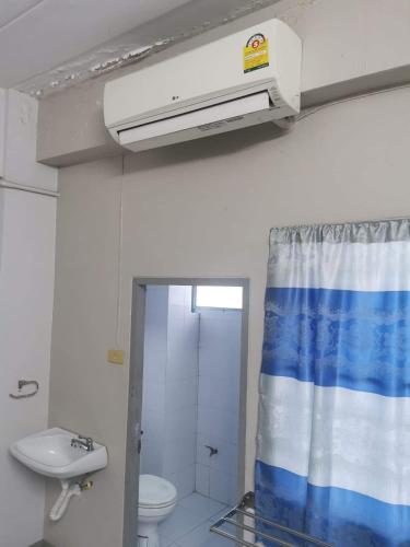 łazienka z umywalką i zasłoną prysznicową w obiekcie Thanya Mansion w mieście Kanchanaburi